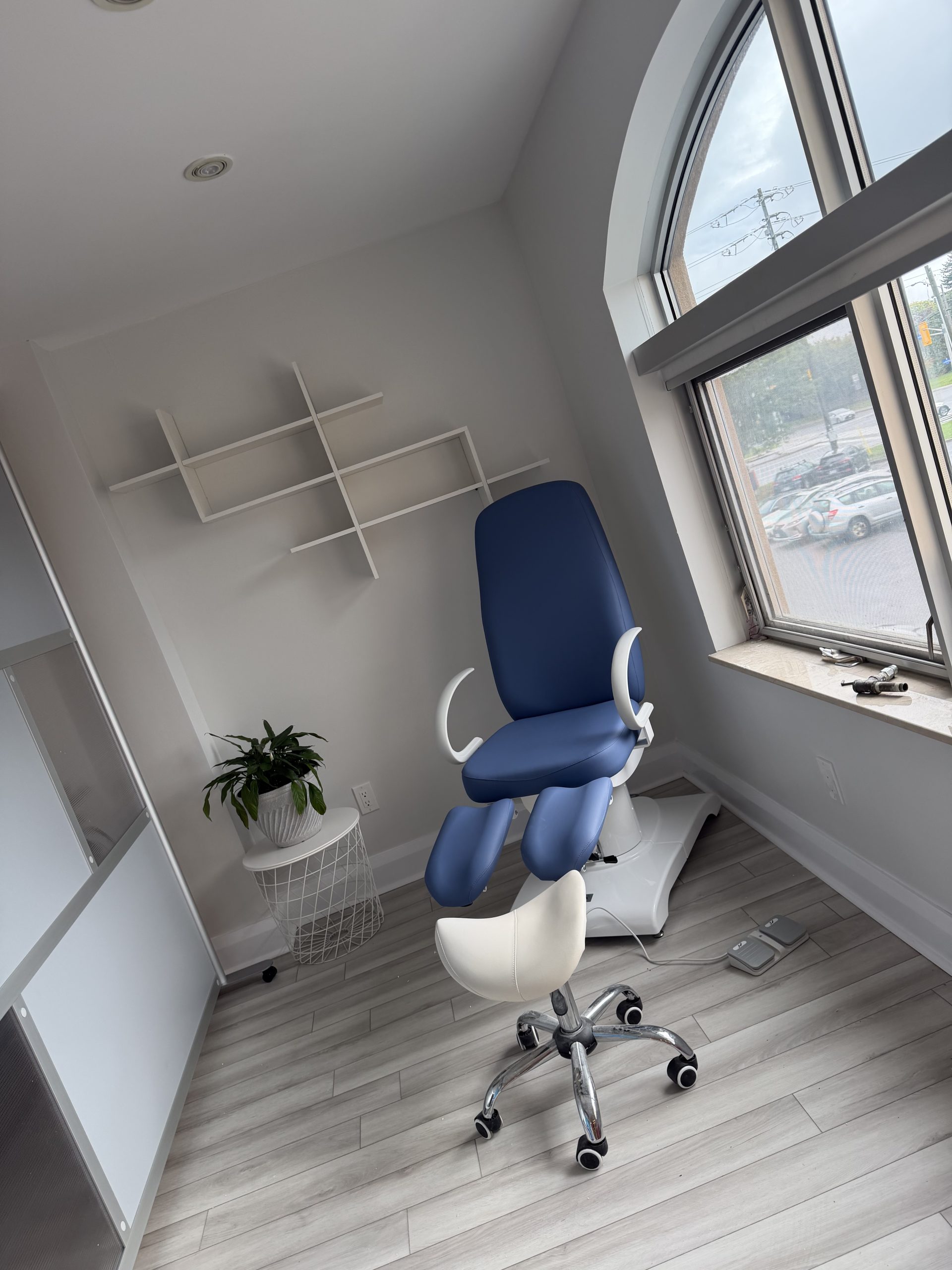 Blue foot care treatment chair beside a large clinic window